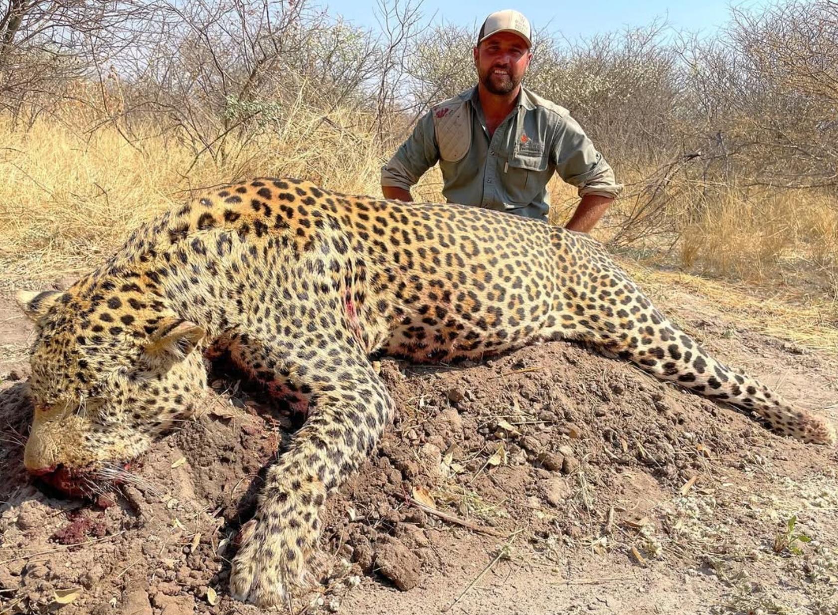 Hunter behind a mature leopard after an African safari